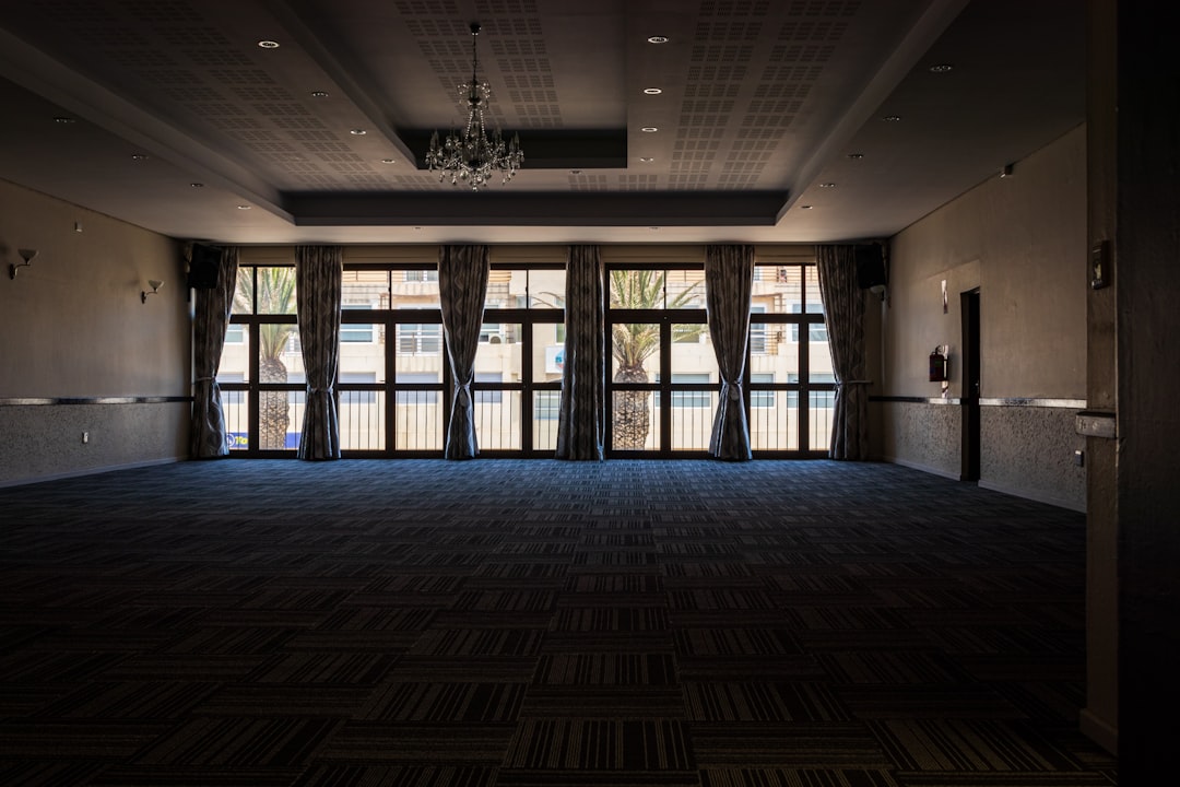 An empty conference ballroom set with chairs and a stage, representing the venue the Local Organizing Committee prepares