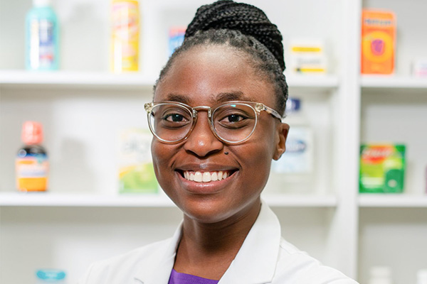 Ruth Adeyemi, a Nigerian-born pharmacy student pictured in a white coat